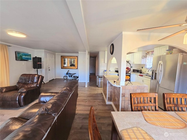 living room featuring hardwood / wood-style floors, ceiling fan, and crown molding