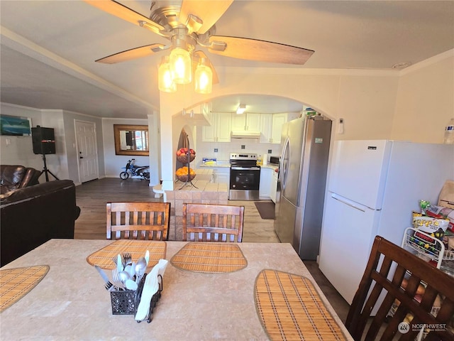 dining room featuring ceiling fan, wood-type flooring, and ornamental molding