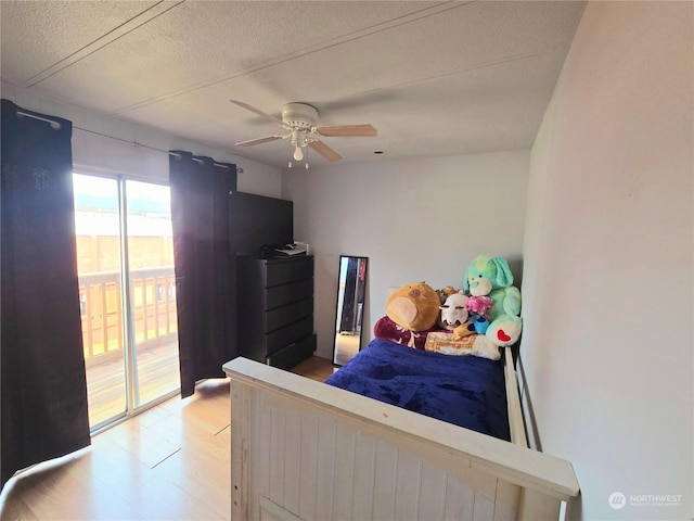 bedroom with hardwood / wood-style floors, a textured ceiling, and ceiling fan