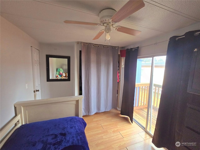 bedroom featuring light hardwood / wood-style floors, baseboard heating, and ceiling fan