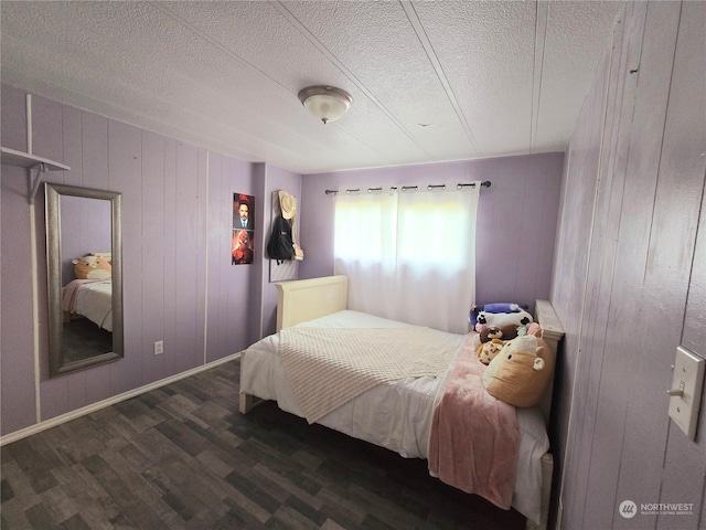 bedroom with a textured ceiling and dark hardwood / wood-style floors