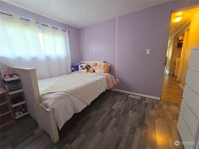 bedroom featuring wood walls and dark hardwood / wood-style flooring