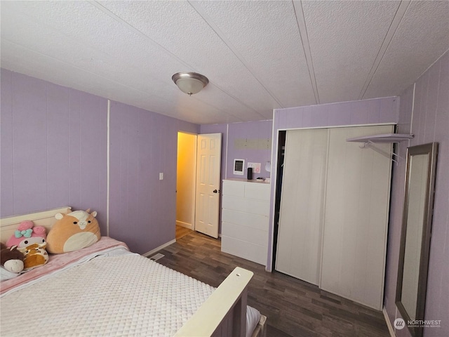 bedroom featuring dark hardwood / wood-style floors, a textured ceiling, and a closet