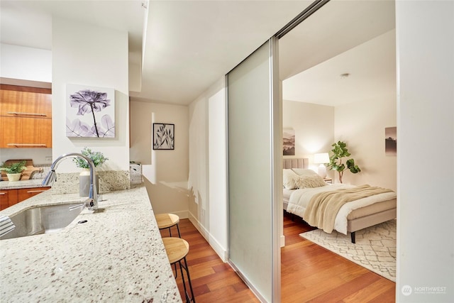 bedroom featuring sink and light wood-type flooring