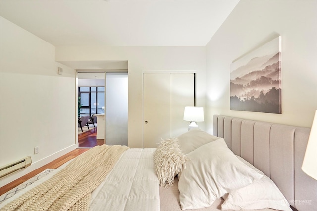 bedroom featuring baseboard heating, hardwood / wood-style floors, and radiator