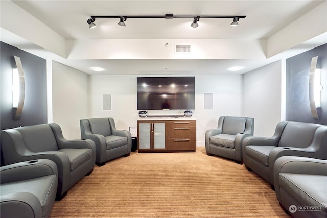 home theater room featuring light colored carpet and rail lighting