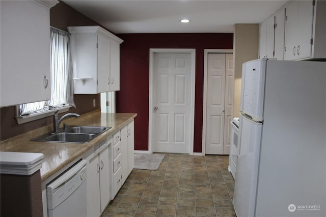 kitchen with light countertops, white appliances, white cabinets, and a sink