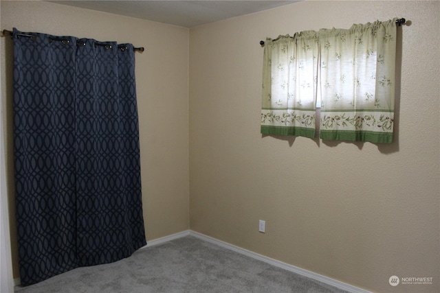 empty room featuring carpet flooring and baseboards