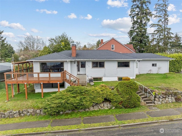 rear view of house with a lawn and a wooden deck