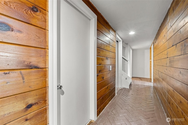 hallway featuring wooden walls