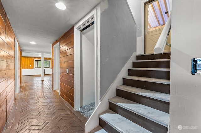 staircase with wood walls