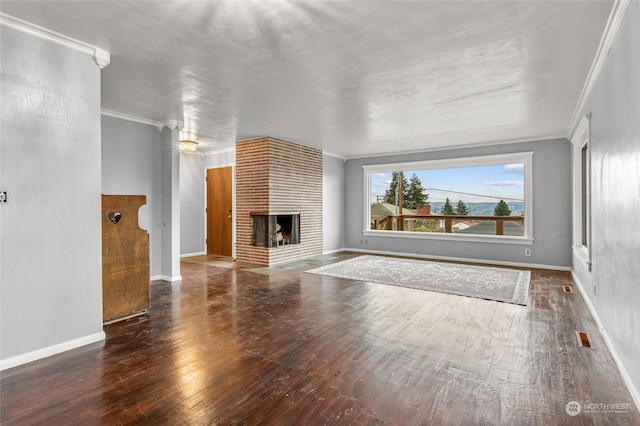 unfurnished living room with ornamental molding, dark hardwood / wood-style floors, and a brick fireplace