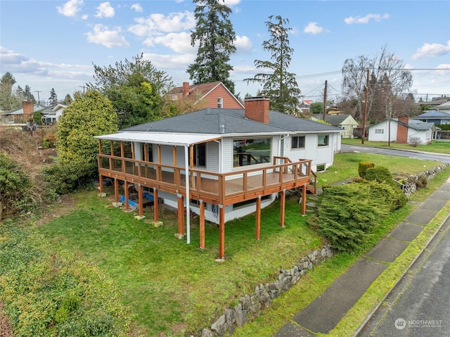 rear view of house with a deck and a yard