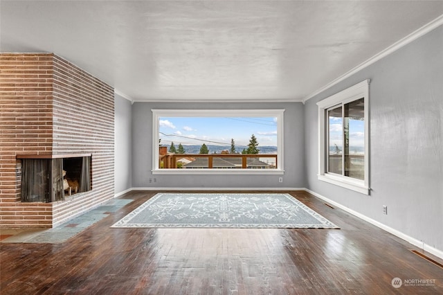 unfurnished living room featuring a multi sided fireplace, dark hardwood / wood-style flooring, and ornamental molding