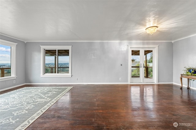 empty room featuring french doors, dark hardwood / wood-style floors, crown molding, and a notable chandelier