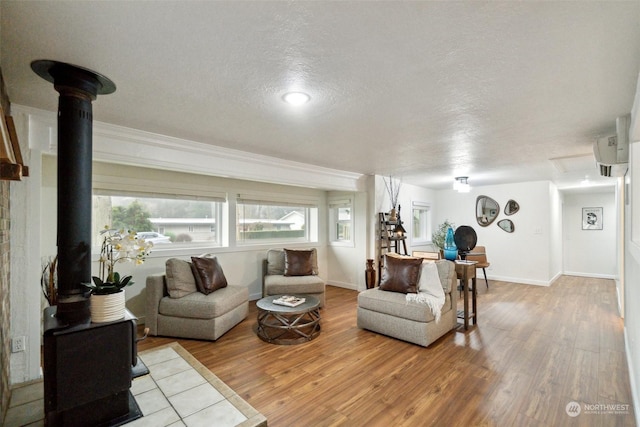 living room featuring hardwood / wood-style flooring, a textured ceiling, and a wood stove