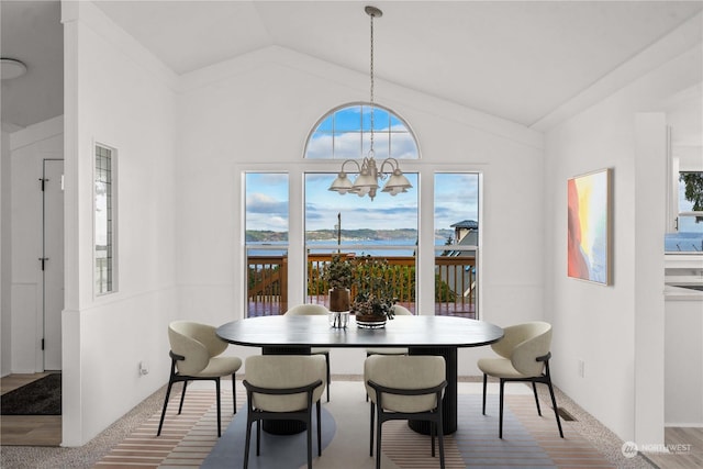 carpeted dining area with a notable chandelier and lofted ceiling