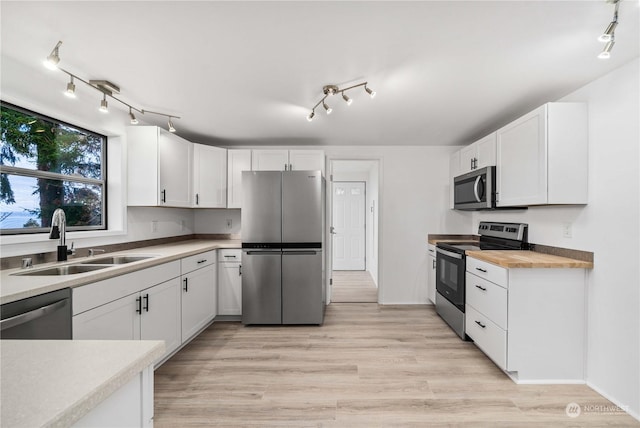 kitchen featuring sink, white cabinetry, light hardwood / wood-style floors, wooden counters, and appliances with stainless steel finishes