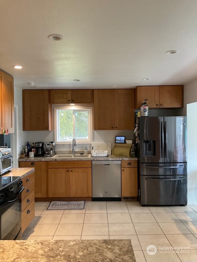 kitchen with light tile patterned flooring, sink, and appliances with stainless steel finishes