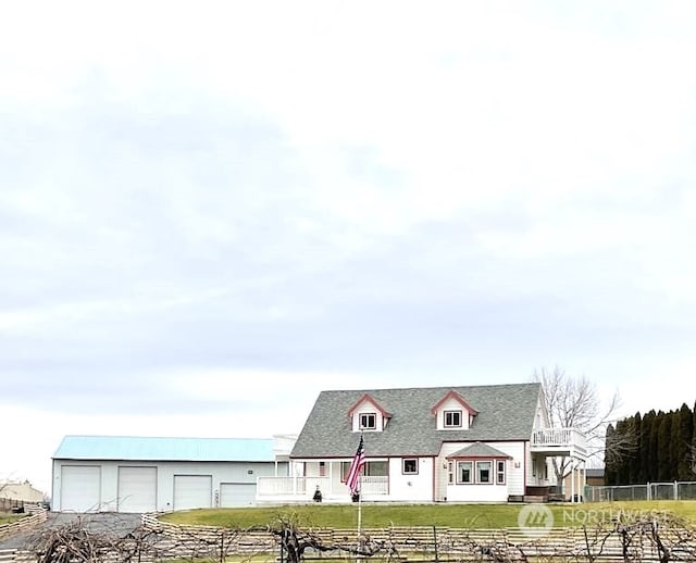 view of front of house with an outbuilding, a garage, and a front lawn