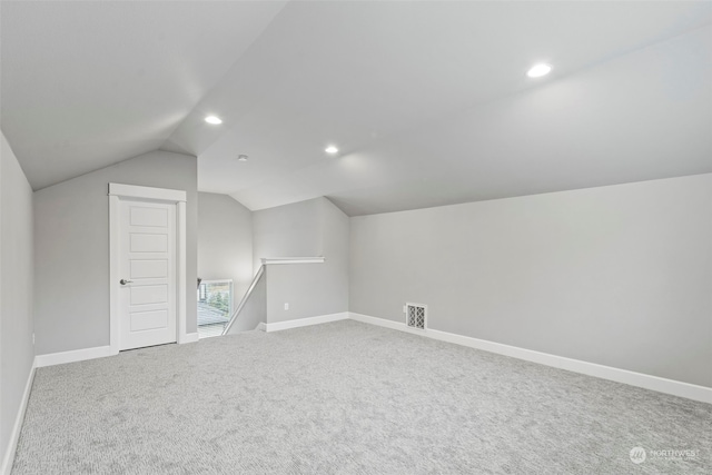 bonus room with vaulted ceiling and carpet floors