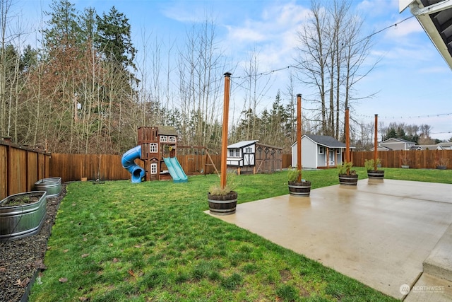 view of yard with a patio, a playground, and a storage unit