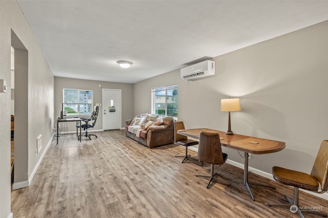 interior space with light wood-type flooring and a wall unit AC