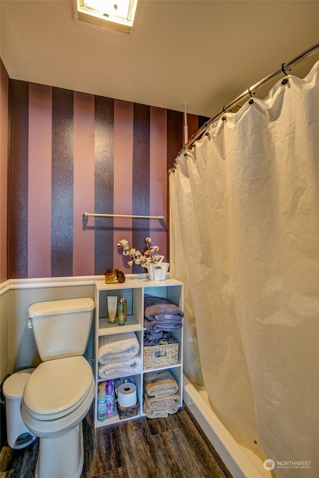 bathroom featuring a shower with curtain, hardwood / wood-style flooring, and toilet