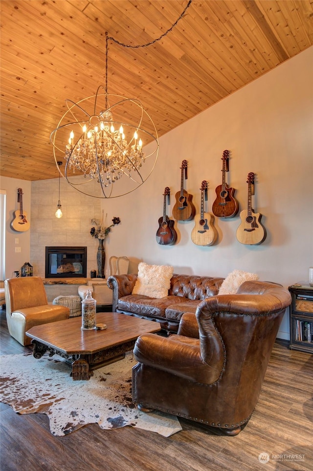 living room featuring a tile fireplace, a notable chandelier, hardwood / wood-style floors, lofted ceiling, and wooden ceiling