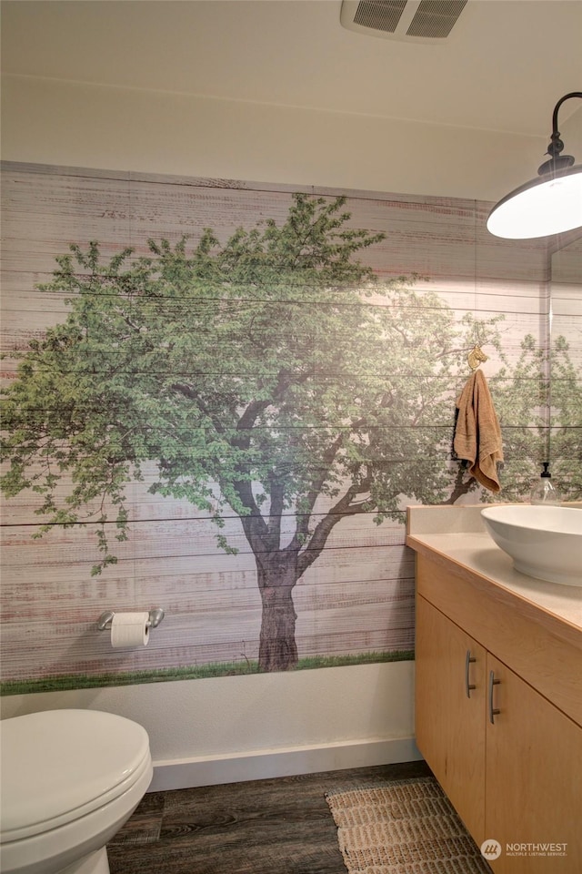 bathroom featuring wood-type flooring, vanity, and toilet