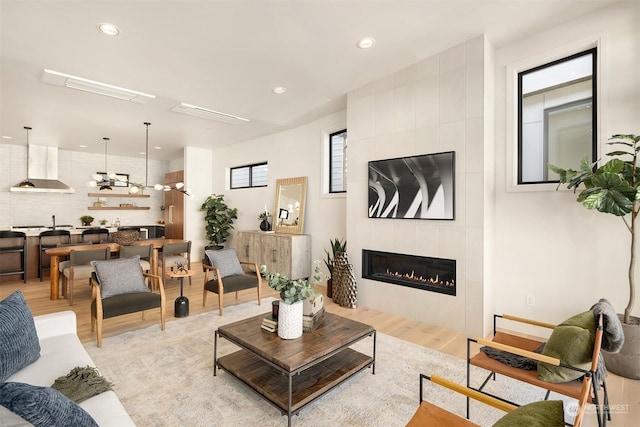 living room featuring light hardwood / wood-style floors and a tile fireplace