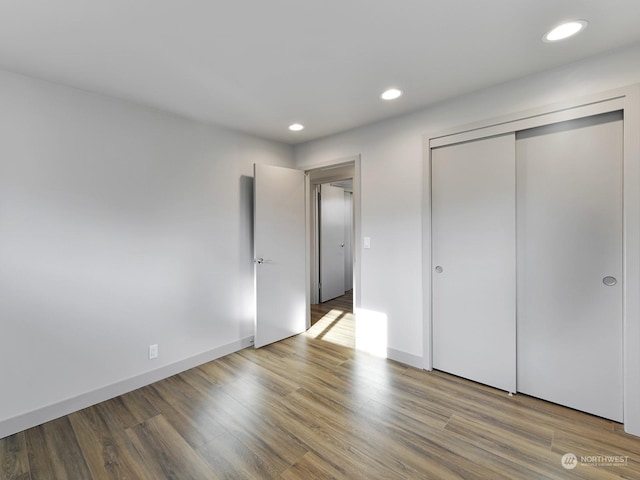 unfurnished bedroom with wood-type flooring and a closet