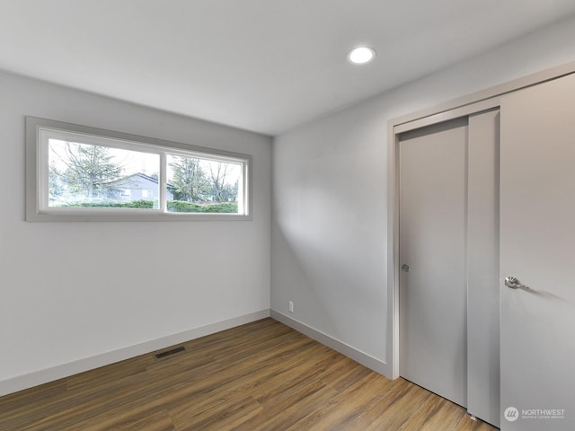 unfurnished bedroom featuring hardwood / wood-style flooring and a closet