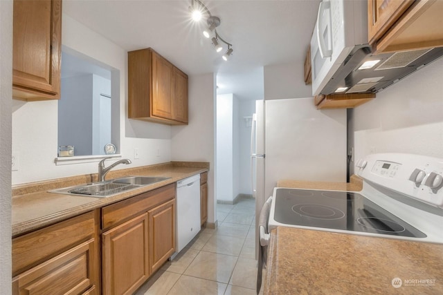 kitchen with sink, track lighting, white appliances, and light tile patterned floors