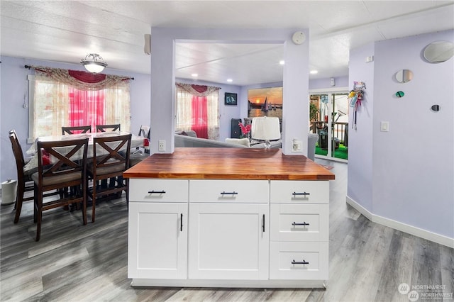 kitchen with white cabinets, light wood-type flooring, and butcher block counters