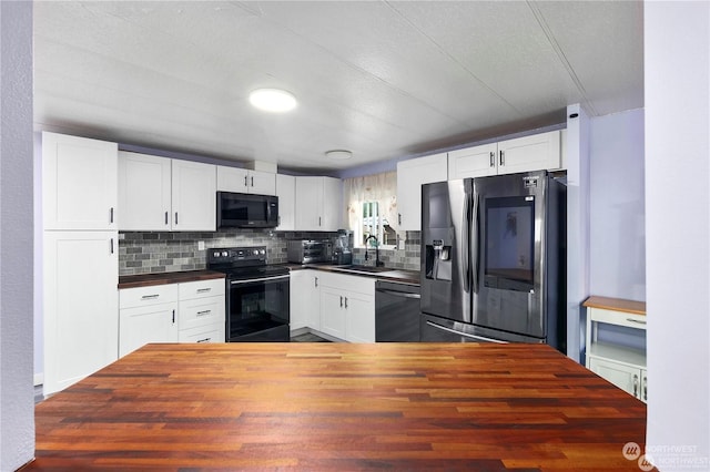 kitchen featuring black appliances, white cabinetry, butcher block counters, and sink