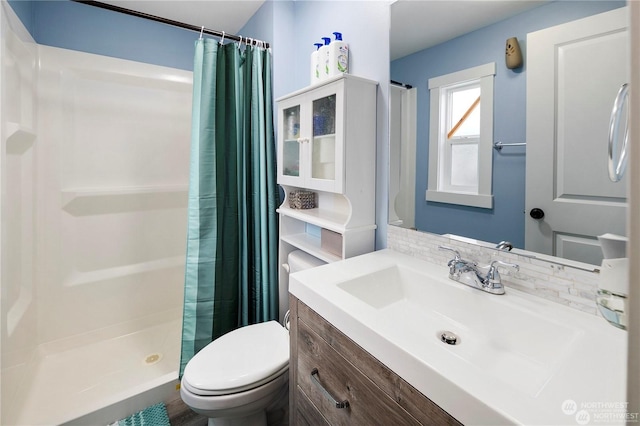 bathroom with decorative backsplash, a shower with curtain, vanity, and toilet