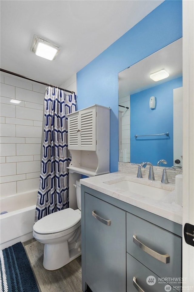 full bathroom with vanity, hardwood / wood-style flooring, toilet, and shower / tub combo with curtain