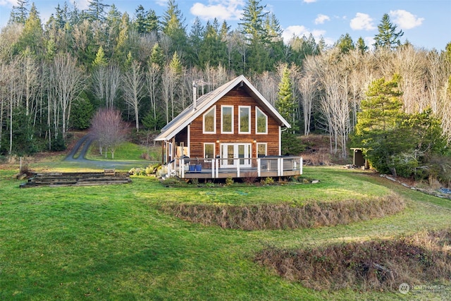 back of property featuring a wooden deck and a yard