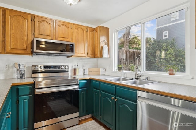 kitchen featuring stainless steel appliances, sink, and backsplash