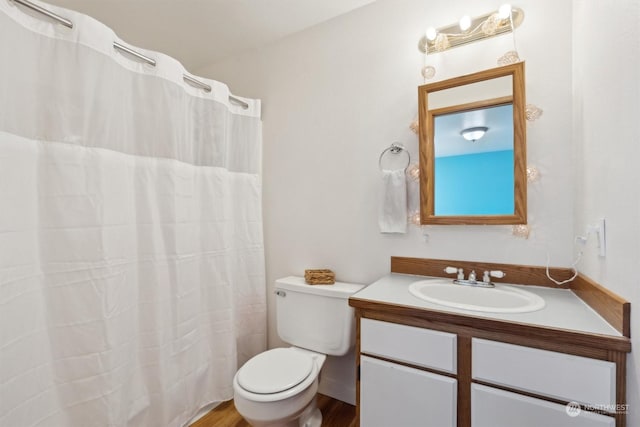 bathroom featuring vanity, toilet, curtained shower, and hardwood / wood-style floors