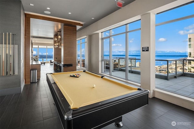 rec room with a water view, pool table, and dark hardwood / wood-style flooring