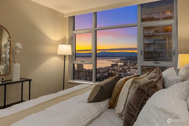 bedroom with floor to ceiling windows and a water view