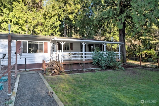 ranch-style home featuring covered porch and a front lawn