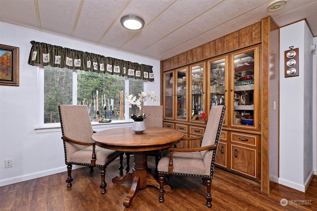 dining area with dark wood-type flooring and a textured ceiling