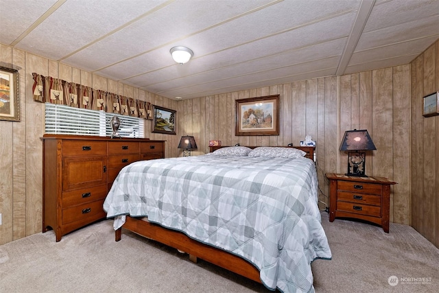 bedroom featuring light carpet and wood walls