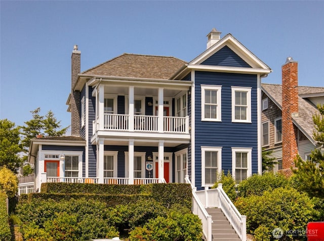 33 Fireside Ln, Pacific Beach, WA 98571 - view of front facade with a balcony, a chimney, and a porch
