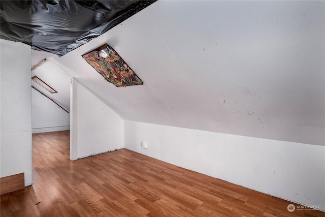 bonus room with lofted ceiling and hardwood / wood-style floors