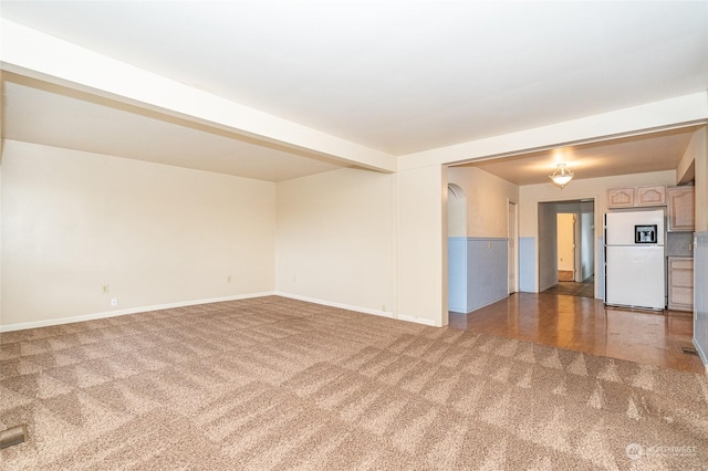 carpeted spare room with beam ceiling