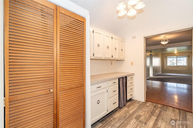 kitchen featuring decorative light fixtures, white cabinets, lofted ceiling, and dark hardwood / wood-style floors